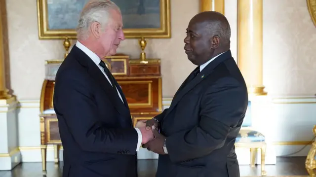 King Charles greets the Prime Minister of the Bahamas, Philip Davis, at Buckingham Palace