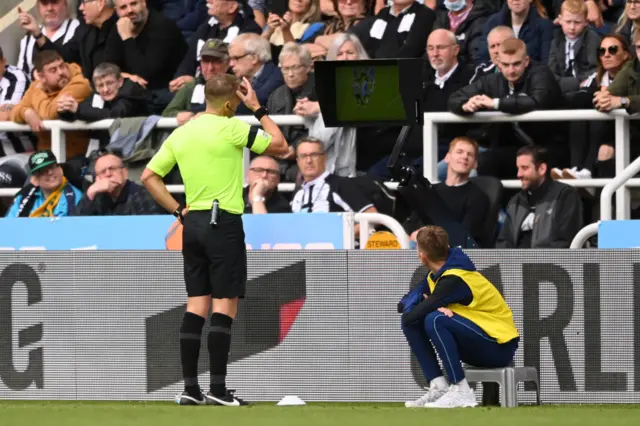 Craig Pawson consults the VAR screen