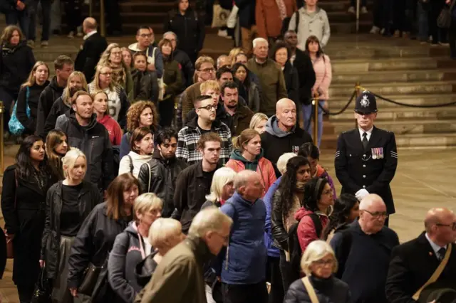 Members of the public walk past the coffin of Queen Elizabeth II, inside Westminster Hall