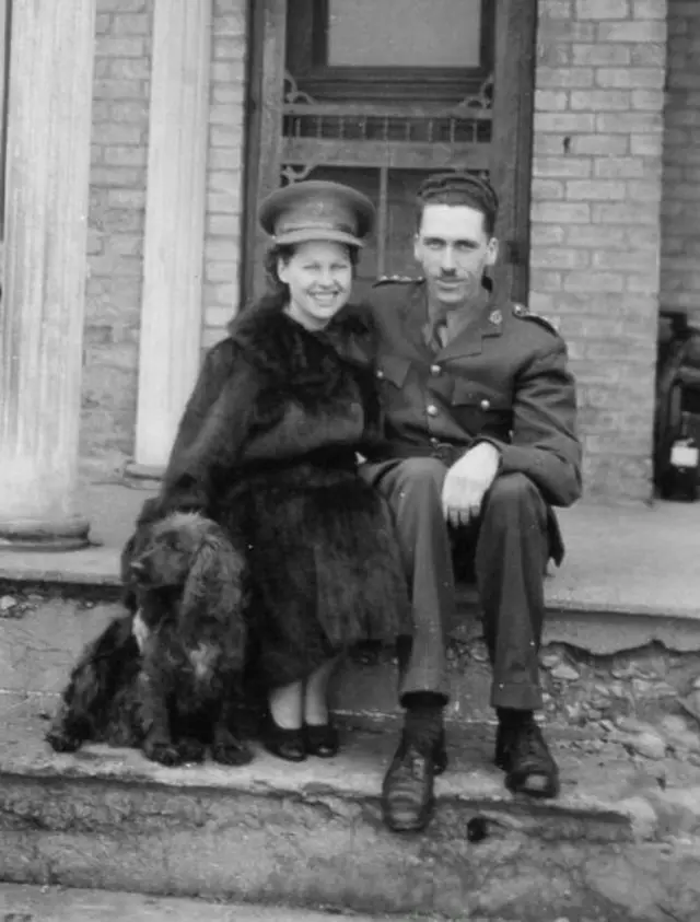 man and woman sitting on steps outside a house