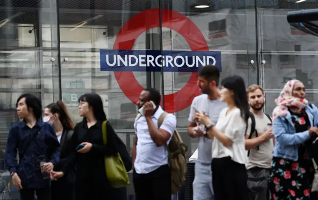 People queue outside Victoria tube station in London