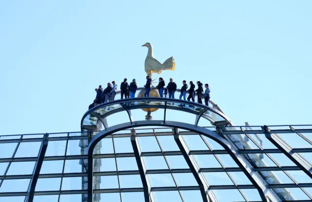 Fans stand on a walkway at the top of the stadium as they take part in the Dare Skywalk ahead of the Premier League match at the Tottenham Hotspur Stadium.