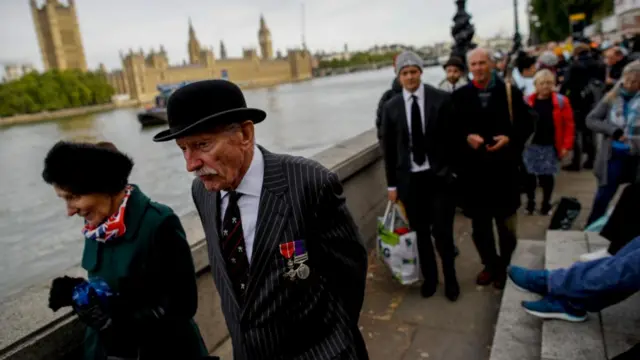 People queue on the banks of the River Thames