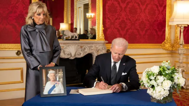 US President Joe Biden accompanied by the First Lady Jill Biden signs a book of condolence at Lancaster House in London, following the death of Queen Elizabeth II