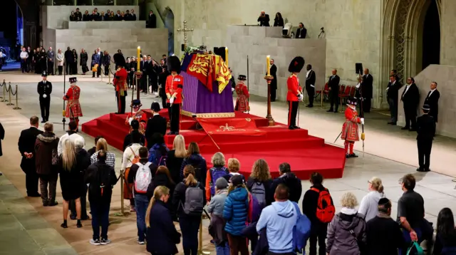 Members of the public observe the national minute's silence in memory of Queen Elizabeth II in Westminster Hall, at the Palace of Westminster, London, where the coffin of the Queen is lying in state on the catafalque.