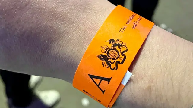 An orange wristband handed out to view the Queen lying in state