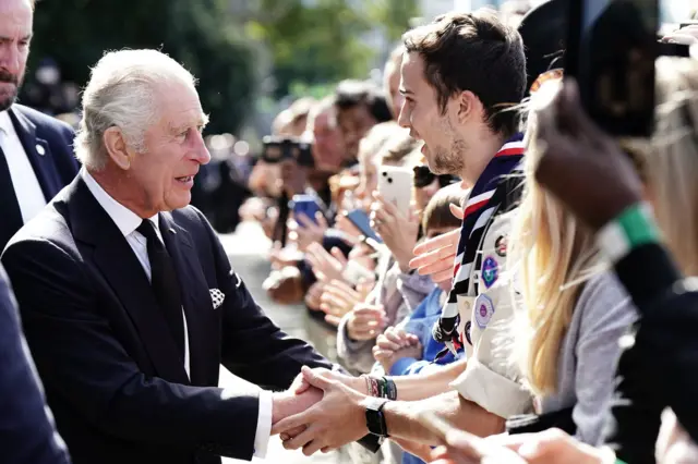 King Charles shakes hands with somebody in the queue to see the Queen lying in state