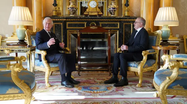 King Charles III sits with Prime Minister of Australia, Anthony Albanese, as he receives realm prime ministers in the 1844 Room at Buckingham Palace i