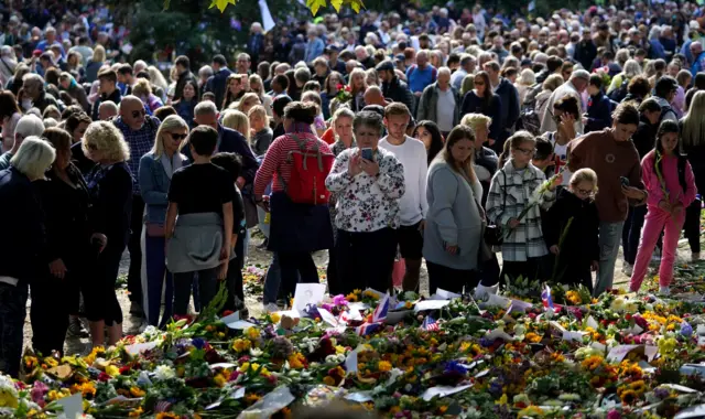 Members of the public place flowers in green park following the death of Queen Elizabeth II. Picture date: Sunday September 18, 2022.