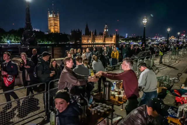 People wait outside overnight in the Queue to see the Queen lying-in-state at Westminster Hall.