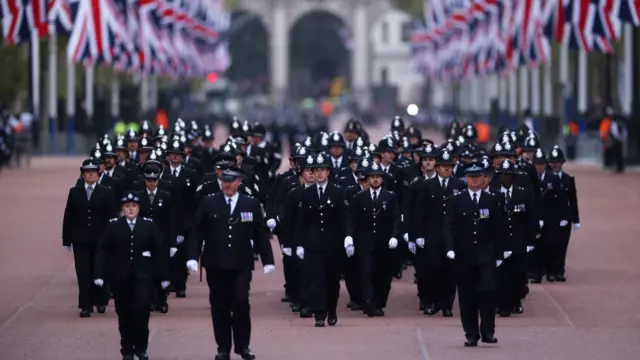 Metropolitan Police Officers are seen walking in formation down The Mall