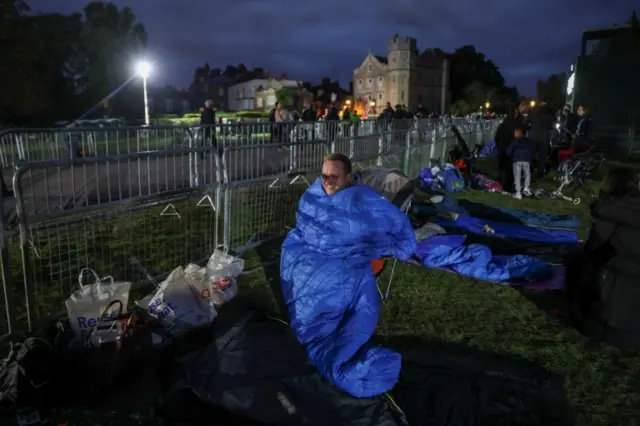 People camp along the fence outside Windsor Castle a day before the funeral procession, following the death of Britain's Queen Elizabeth, in Windsor on 18 September 2022