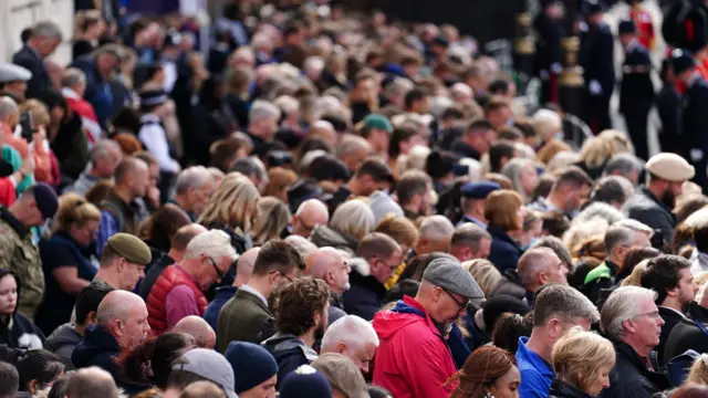 Crowds listen on Horse Guards Avenue during the Queen's funeral