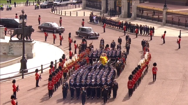 Staff gather outside Buckingham Palace as coffin passes