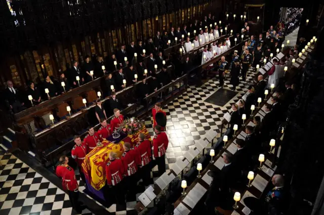 The coffin of Queen Elizabeth II followed by (left to right, from front) King Charles III, the Queen Consort, the Princess Royal, Vice Admiral Sir Tim Laurence, the Duke of York, the Earl of Wessex, the Countess of Wessex, the Prince of Wales, Prince George, Princess Charlotte, the Princess of Wales, the Duke of Sussex, the Duchess of Sussex, Peter Phillips, the Earl of Snowdon, the Duke of Gloucester, the Duke of Kent, and Prince Michael of Kent