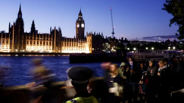 The Palace of Westminster in the background as people queue