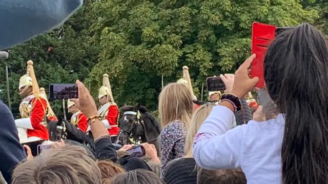 Crowds on the Long Walk holding their phones to take pictures of the procession