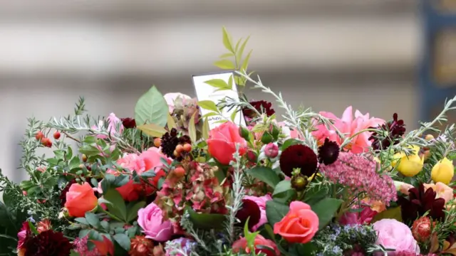 Card on wreath on top of Queen's coffin