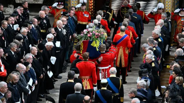 The Queen's coffin is led up the Abbey