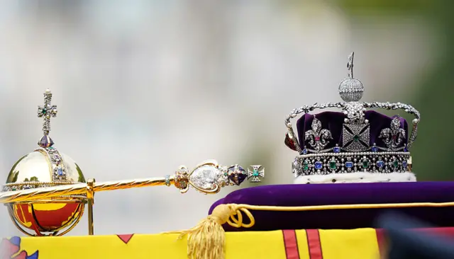 The coffin is draped in the Royal Standard with the Imperial State Crown and the Sovereign's orb and sceptre, in the Ceremonial Procession following her State Funeral at Westminster Abbey