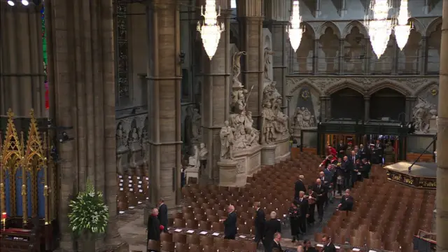 People walk up the aisle at Westminster Abbey