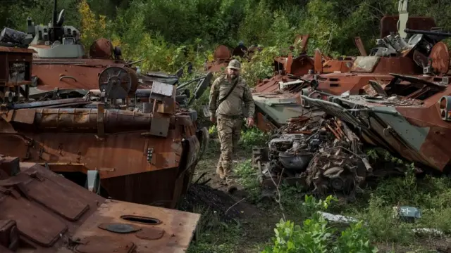 Ukrainian serviceman walks near destroyed RussianArmoured Personnel Carriers (APC), as Russia's attack on Ukraine continues, in the town of Izium, recently liberated by Ukrainian Armed Forces, in Kharkiv region, Ukraine September 20, 2022.