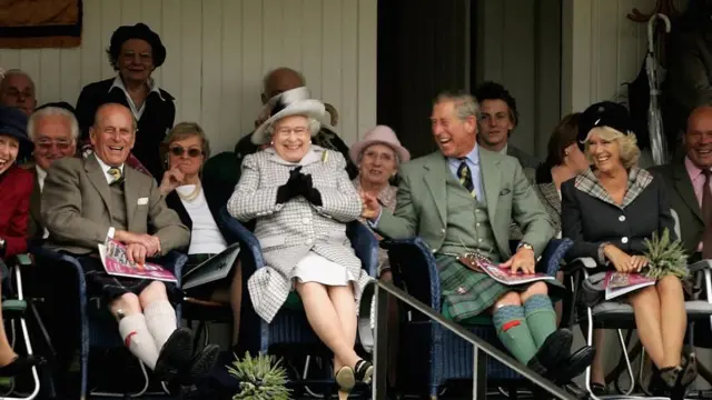 The Queen and members of the Royal Family break into laughter as they watch the tug-of-war during the Braemar Gathering in 2006