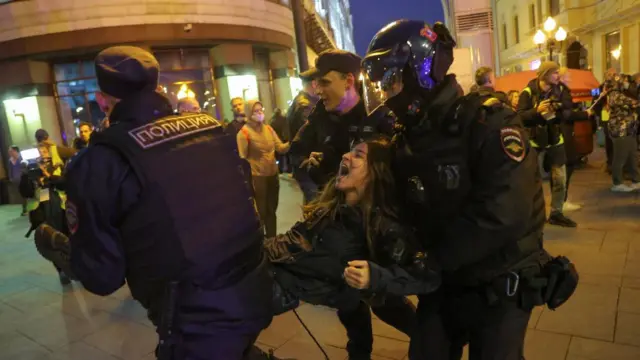 Russian police officers detain a protester during an unsanctioned rally in Moscow