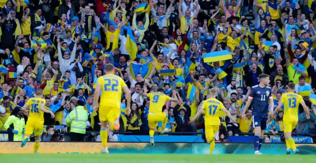 Roman Yaremchuk celebrates with the away fans after doubling Ukraine's lead