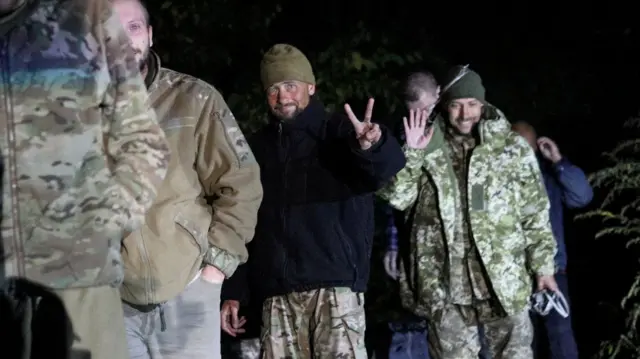 Ukrainian prisoners of war smile - with one giving the peace sign - after more than 200 Ukrainian soldiers were exchanged for 55 Russian troops last night