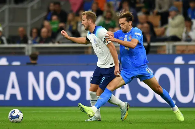 Harry Kane competes for the ball with Rafael Toloi