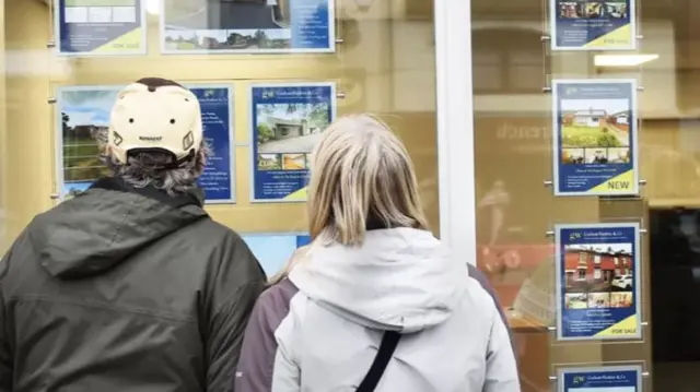 People looking in estate agent's window