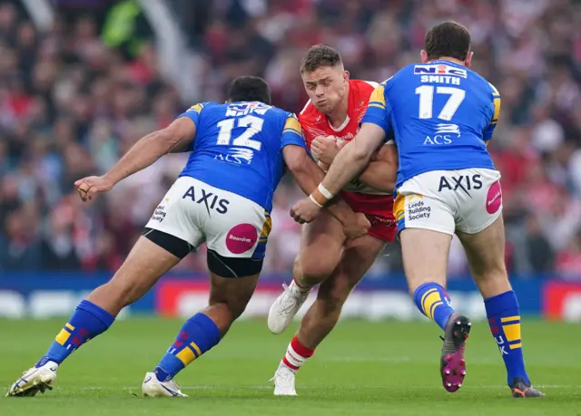 St Helens' Morgan Knowles (centre) is tackled by Leeds' Rhyse Martin (left) and Cameron Smith