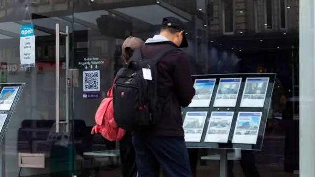 People looking at estate agents window