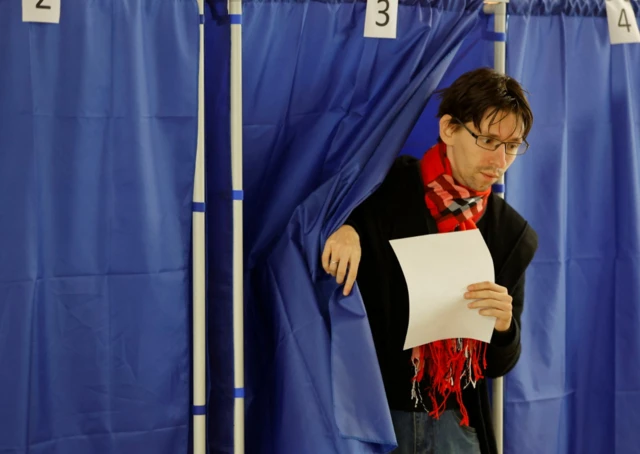 A man comes out of a voting booth at a polling station during a referendum on the joining of the self-proclaimed Donetsk People's Republic (DPR) to Russia, in Donetsk, Ukraine September 27, 2022