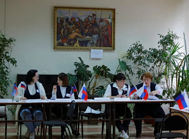 Members of an electoral commission wait for voters at a polling station during a referendum on the joining of the self-proclaimed Donetsk People's Republic (DPR) to Russia, in Donetsk, Ukraine September 27, 2022.