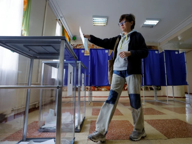 A woman casts her ballot at a polling station during a referendum on the joining of the self-proclaimed Donetsk People's Republic (DPR) to Russia, in Donetsk, Ukraine September 27, 2022.