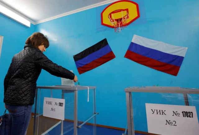 A woman casts her ballot at a polling station during a referendum on the joining of the self-proclaimed Donetsk People's Republic