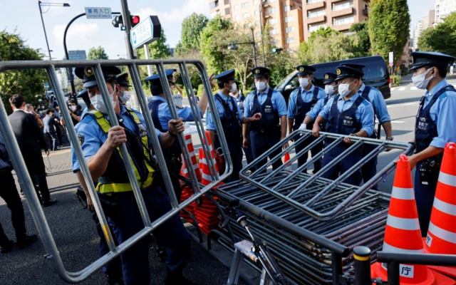 Police officers set up fences at the entrance gate toward Nippon Budokan Hall which will host a state funeral