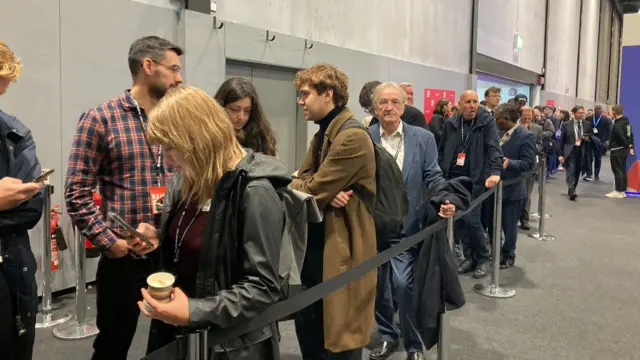 People queue outside the conference hall