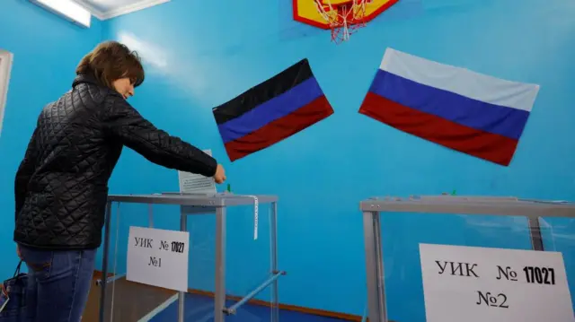 A woman casts her ballot at a polling station during a so-called referendum on the status of Donetsk