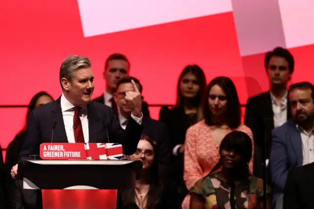 Starmer gestures by holding up a finger as he delivers his speech