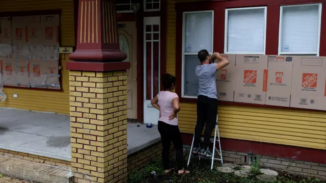 People attempt to weather proof a home with cardboard in Tampa, Florida