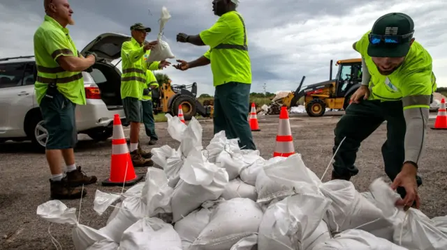 City workers and volunteers deliver UP sand bags in the city of St Petersburg, on Florida's gulf coast