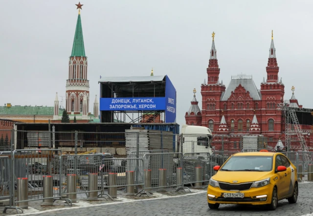 A banner reads: "Donetsk, Luhansk, Zaporizhzhia, Kherson. Together forever!" in Red Square in Moscow