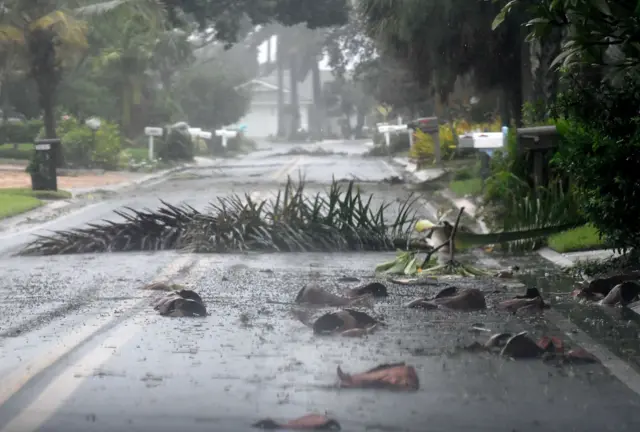 Road littered and pummelled with rain amid heavy hurricane winds.