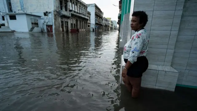 A woman stands on a flooded street in Havana on Wednesday