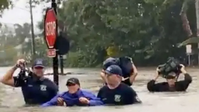 Firefighters stand in flood water as the fire station gets inundated in Naples, Florida