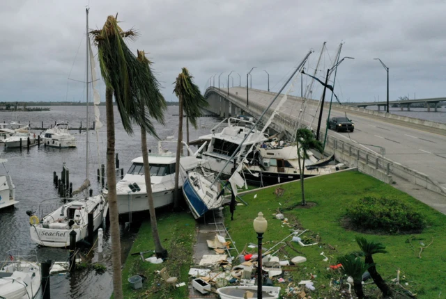 Boats are pushed up on a causeway after Hurricane Ian passed through the area on 29 September 2022