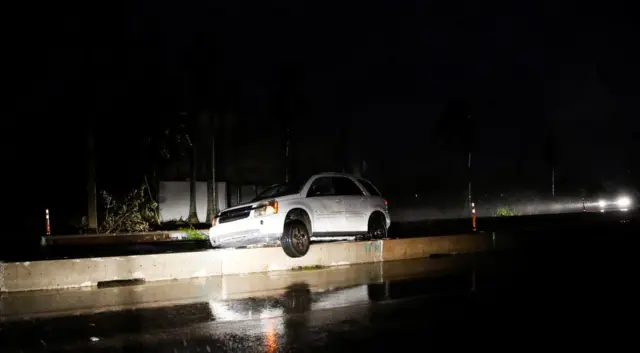 A car is stranded on a street as Hurricane Ian makes landfall in southwestern Florida